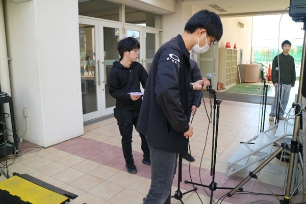 イベント会場でマイクを設置している学生