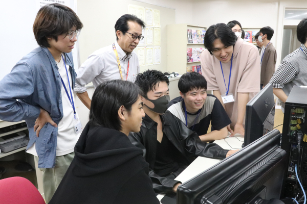 作品を見る先生と学生たち