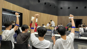 腕を上げてポーズする学生