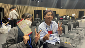 カメラに向かってピースをする学生