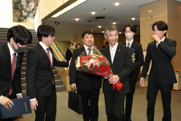 先生に花束を渡す学生たち
